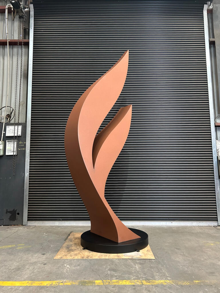Dicot is a contemporary sculpture by Lump, crafted from Corten steel with a rusted patina and stainless steel details, inspired by the forms of plant seeds.