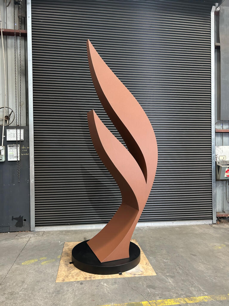 Dicot is a contemporary sculpture by Lump, crafted from Corten steel with a rusted patina and stainless steel details, inspired by the forms of plant seeds.