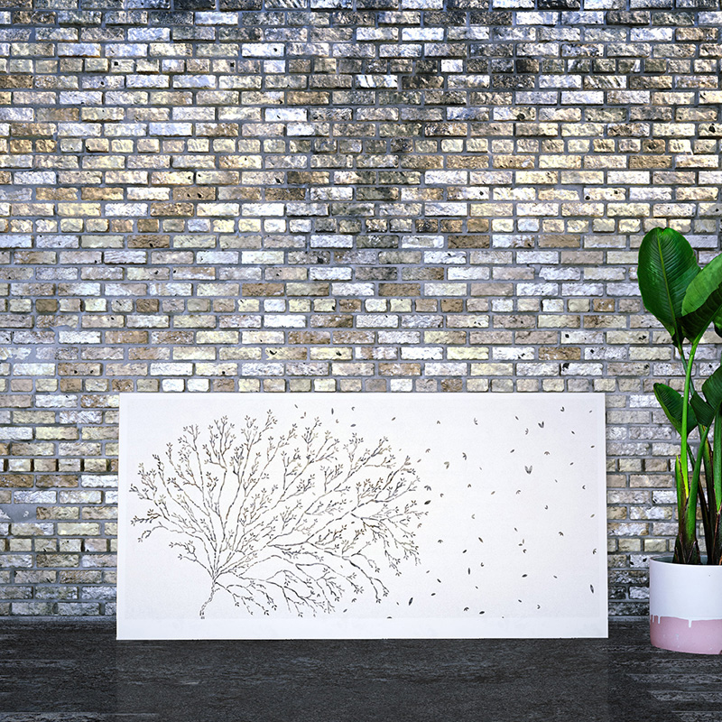 Laser cut metal garden screen painted white leaning on factory wall