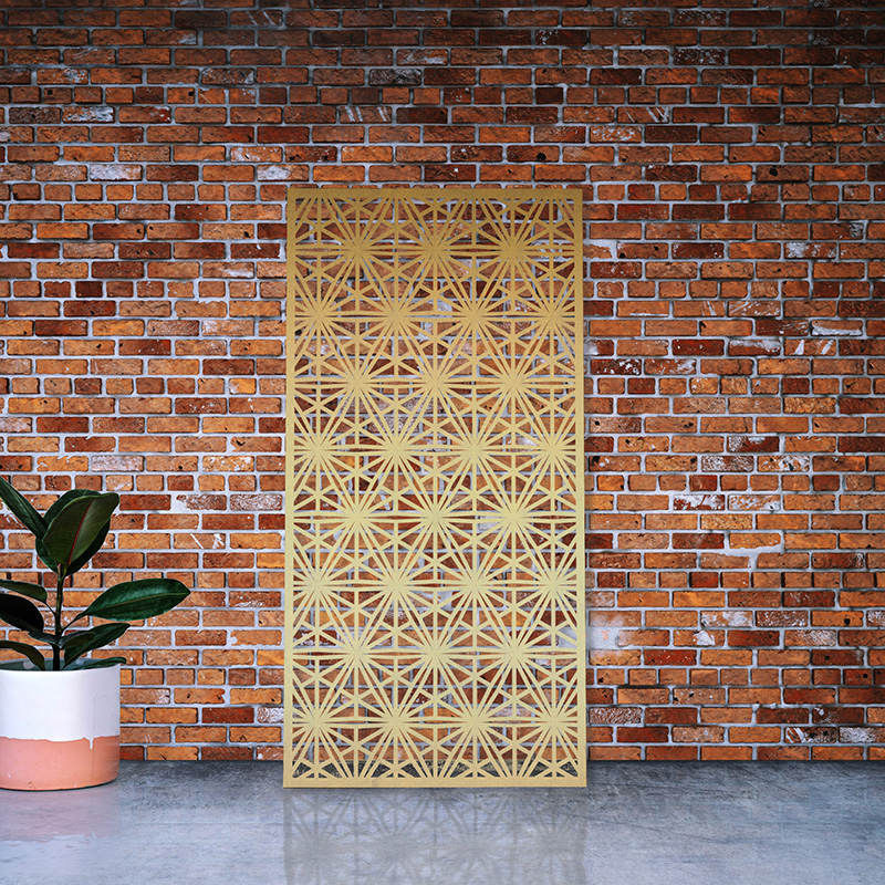 Brass metal garden screen leaning on factory wall