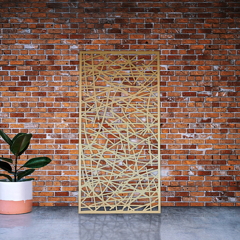 Brass metal garden screen leaning on factory wall