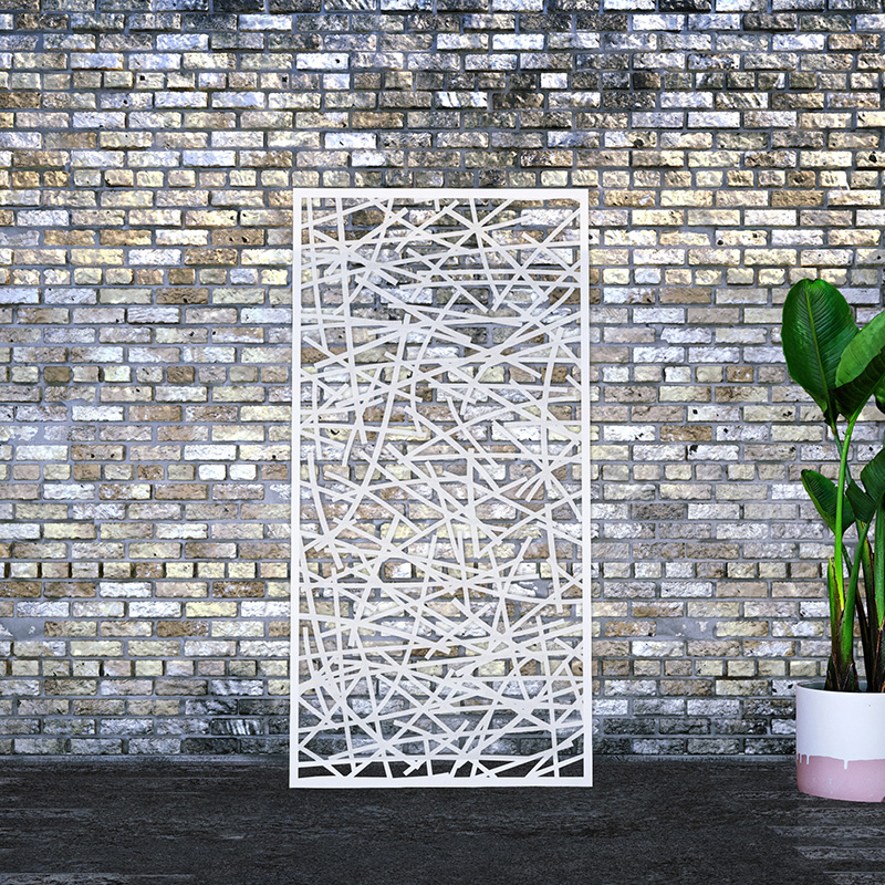 Outdoor metal screen with decorative laser cut design leaning on factory wall