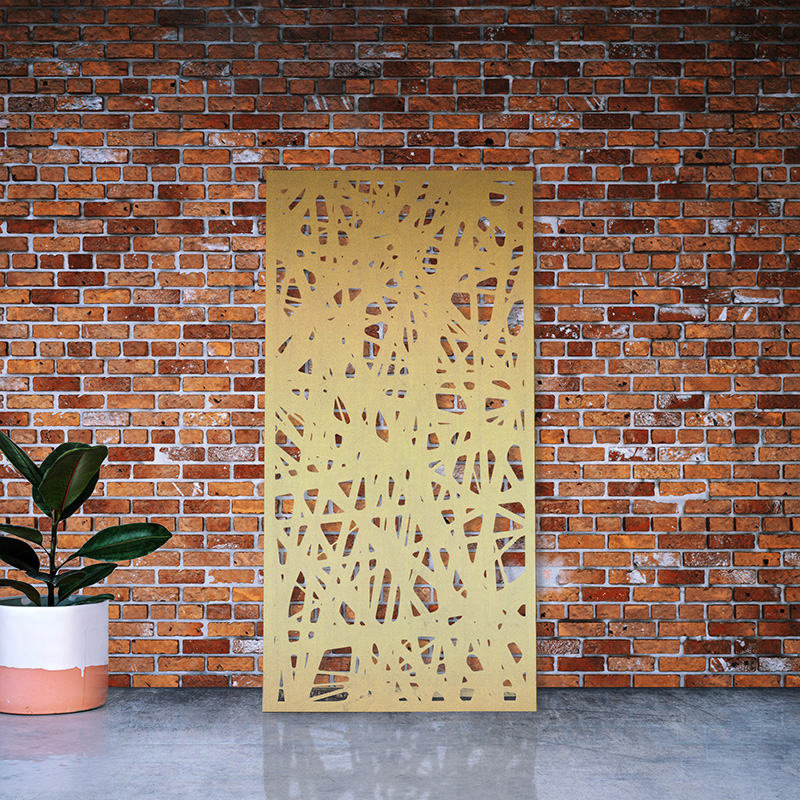 Laser cut Brass Metal Screen leaning on red brick factory wall