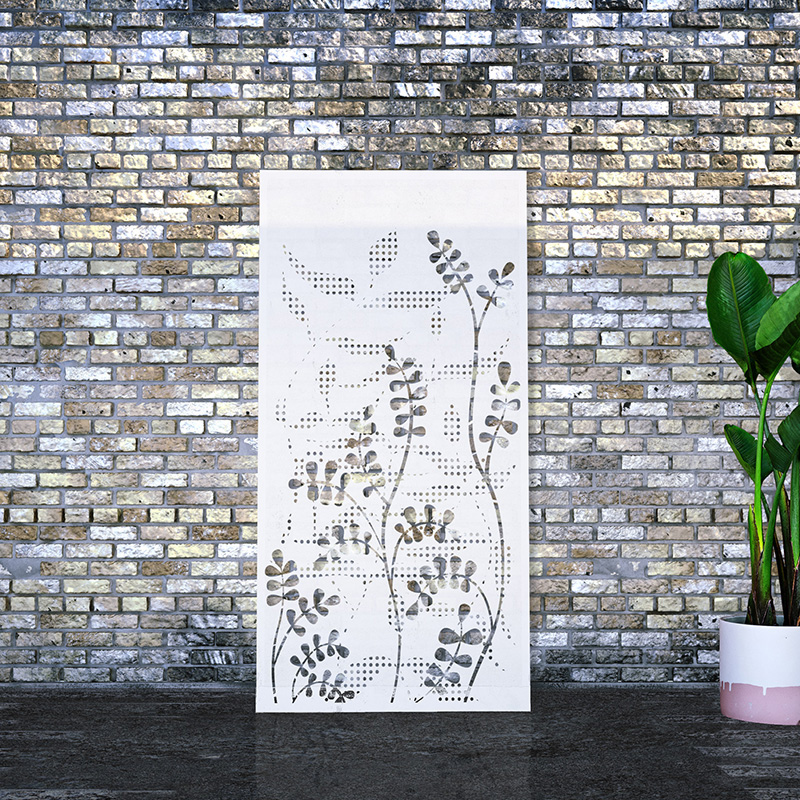 White metal garden screen with decorative screen design leaning on factory wall
