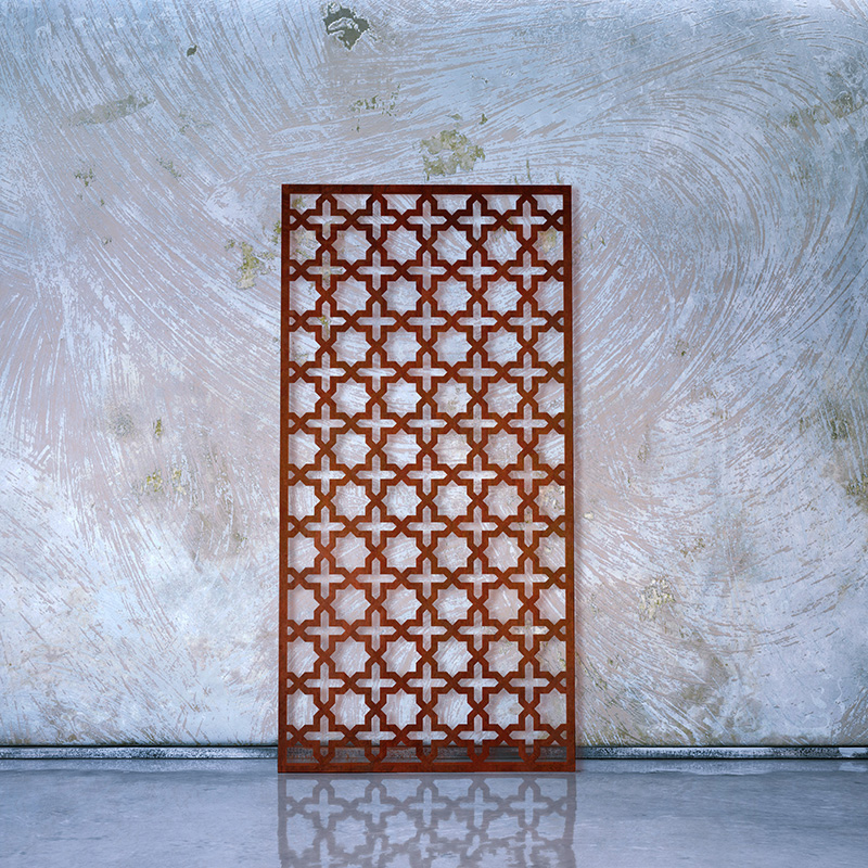 Corten Steel Rusted Decorative Laser Cut Screen leaning on whitewashed factory wall