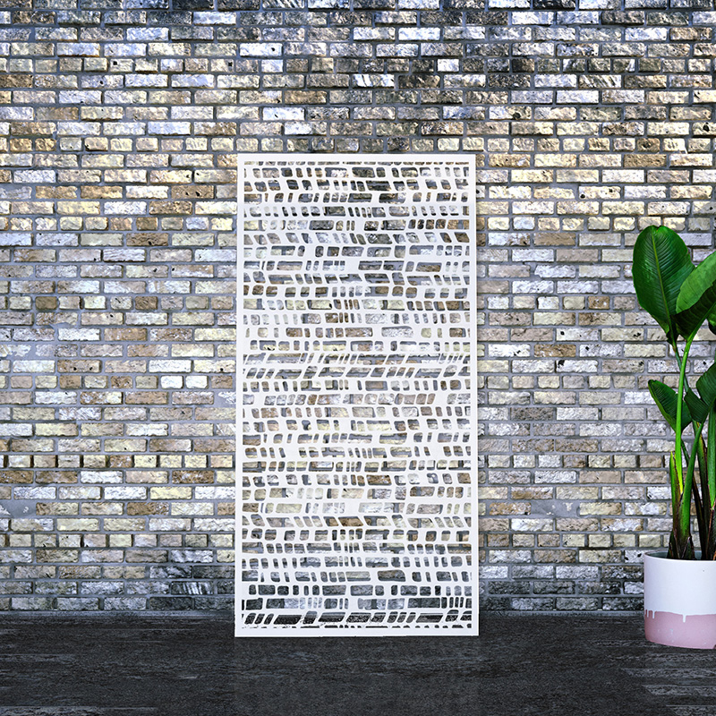 White Laser Cut Privacy Screen leaning on vintage brick wall