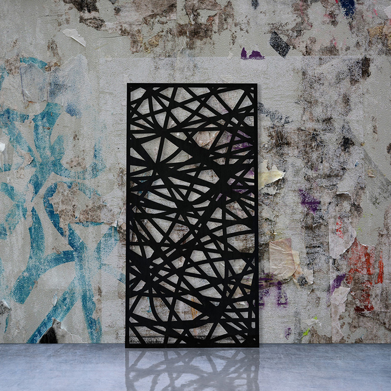 Black Laser Cut Metal Screen leaning on factory wall with torn posters