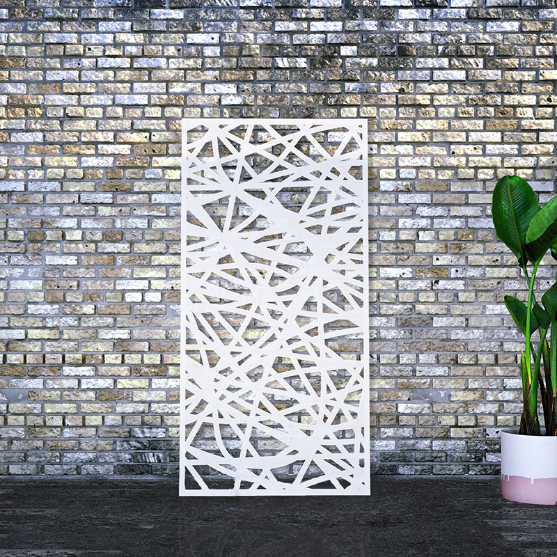 Laser cut screen powder coated white leaning against an old brick factory wall