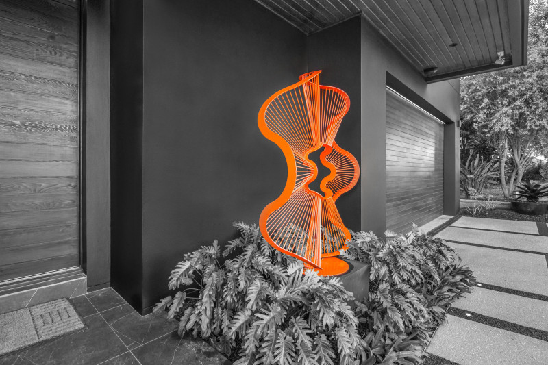 Lump Sculpture Studio Amplitudes Sculpture Bright Orange Round Sculpture an entrance to modern architectural home
