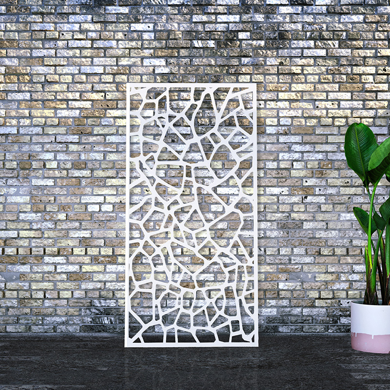 Laser cut screen powder coated white leaning against an old brick factory wall