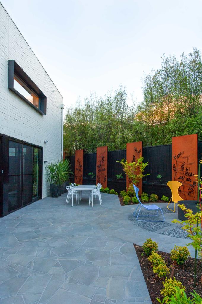 Corten steel screens with rusted finish and laser cut design in garden