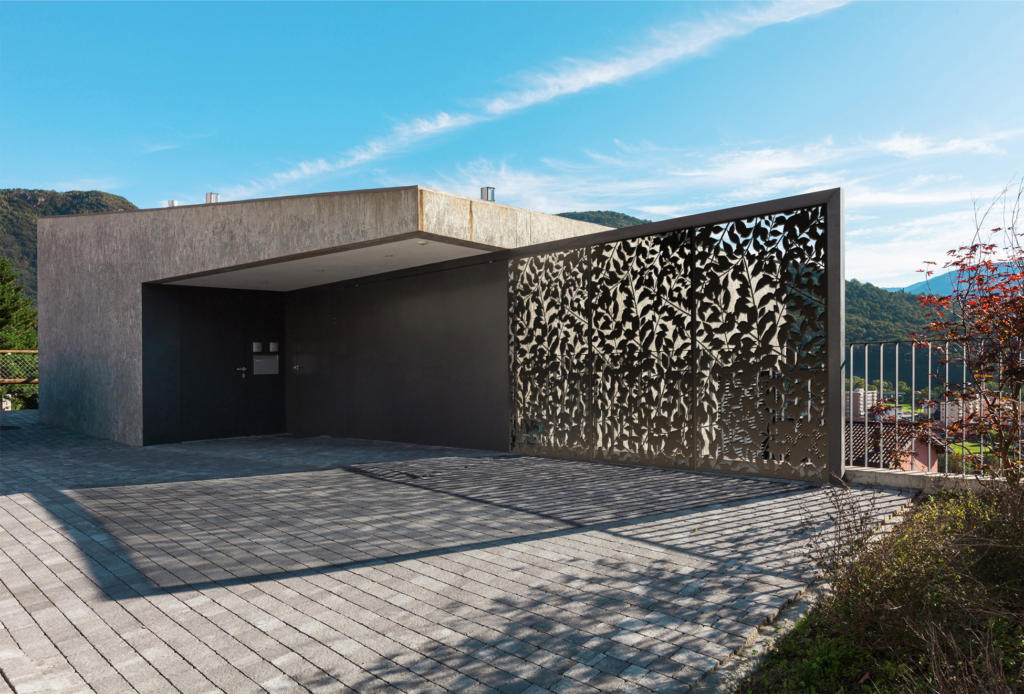 Bronze laser cut decorative screens used as fence and privacy screen for modern entrance to architectural home and landscape