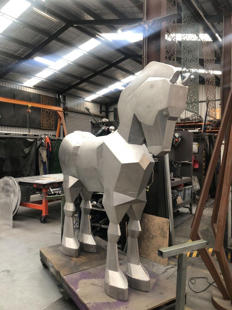 Large Trojan Horse sculpture designed for climbing and riding in a modern playground landscape