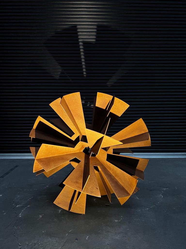 Rusted sculpture depicting a dandelion flower by Lump Sculpture Studio