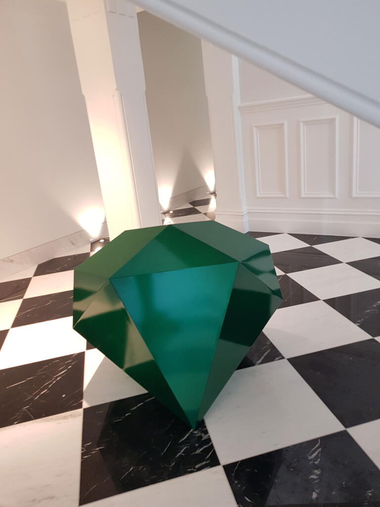 Large sculpture of a round brilliant cut Emerald gemstone;
