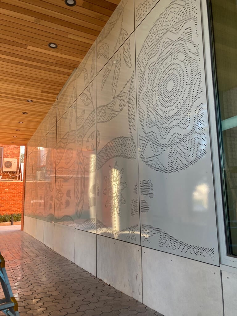 Mural made from perforated aluminium honouring the Wurundjeri People of the Kulin Nations representing children’s education and life's journey designed by Dixon Patten fabricated by Lump Studio installed at Preston South Primary School