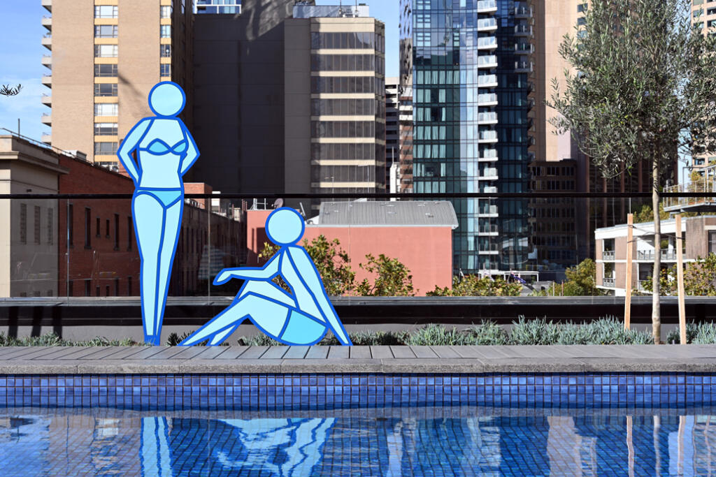 Two Blue Sun Bathers designed by Stephen Baker are new sculptures fabricated by Lump Studio installed by the pool at Le Méridien Melbourne