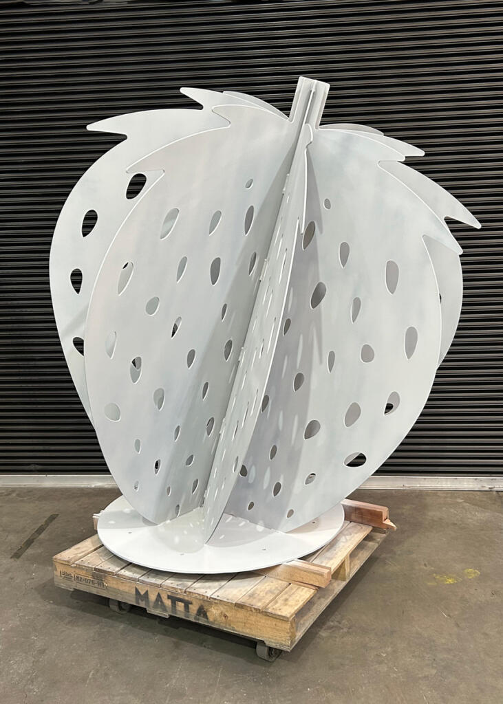 Large red strawberry sculpture at Yarra Farm Fresh, created by Lump Sculpture Studio, serving as a photo landmark for visitors.