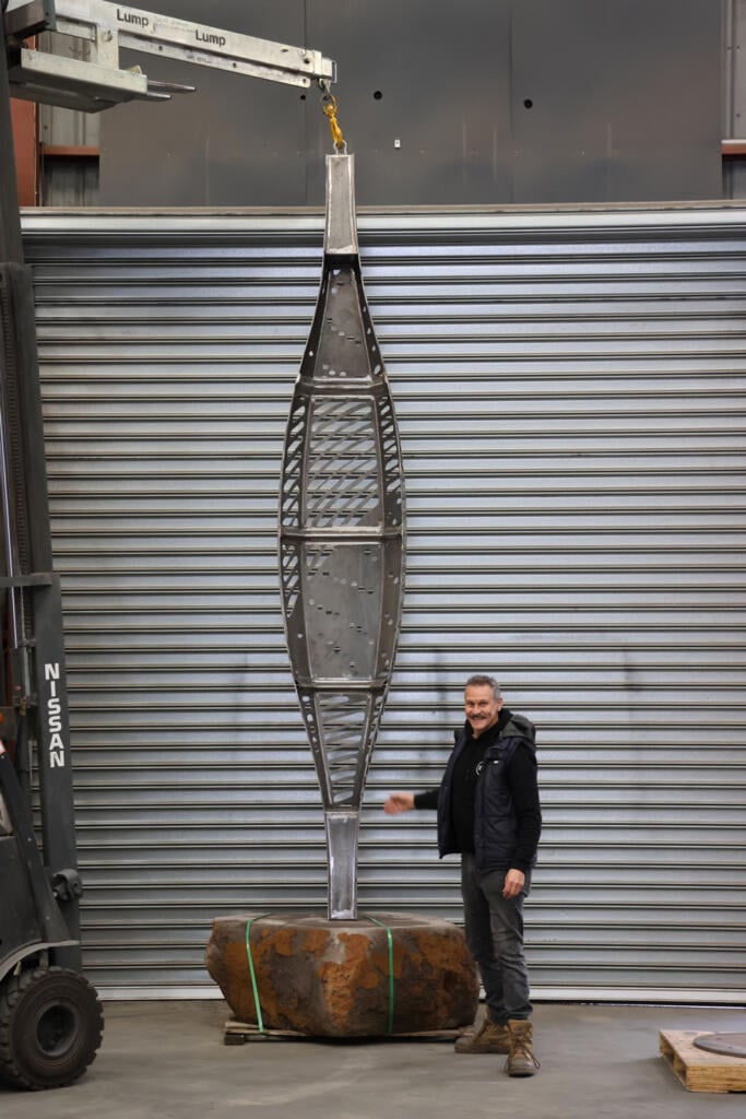Corten steel and stainless steel canoe sculpture by First Nations artist Simone Thomson, fabricated by Lump Studio, installed on natural rock in Port Melbourne.