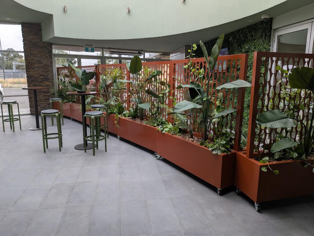 Custom Corten steel planter with drop-in pot system allowing individual potted native plants to be easily removed and replaced.